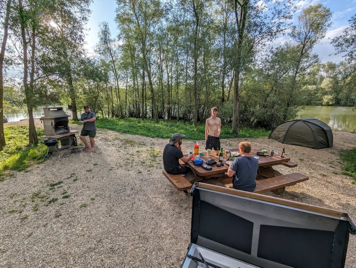 Group of anglers at picnic table by the lake